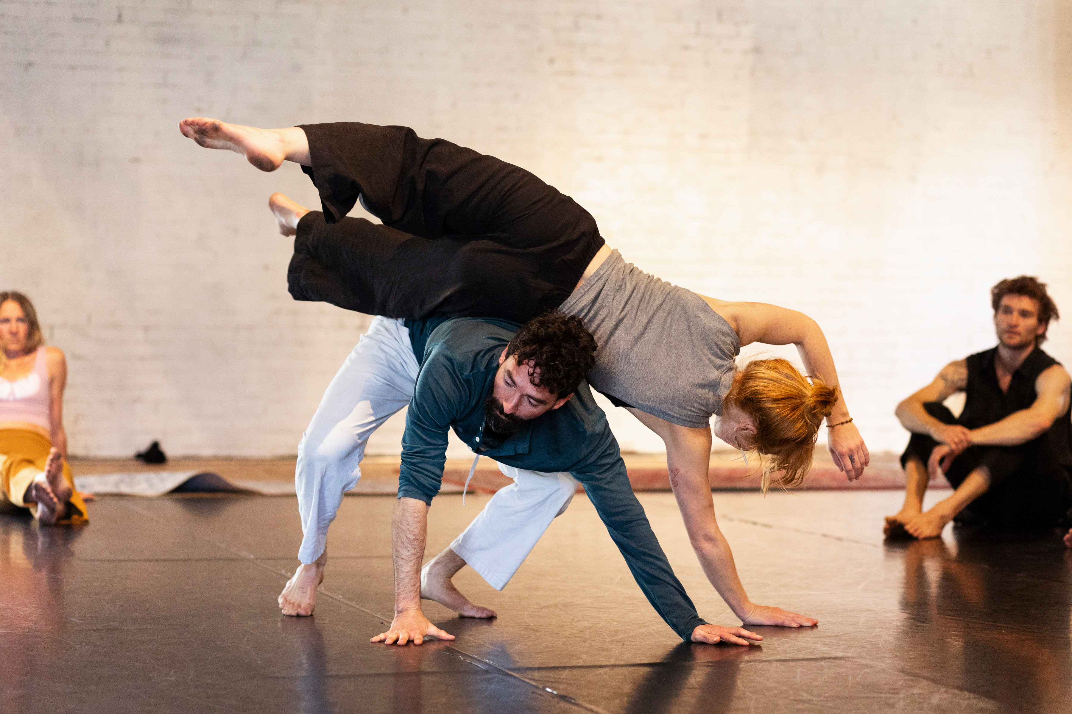 Two dancers sharing weight in contact improvisation